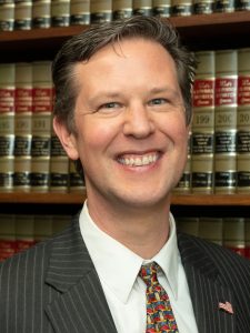 Brett Peterson in his office in front of legal books